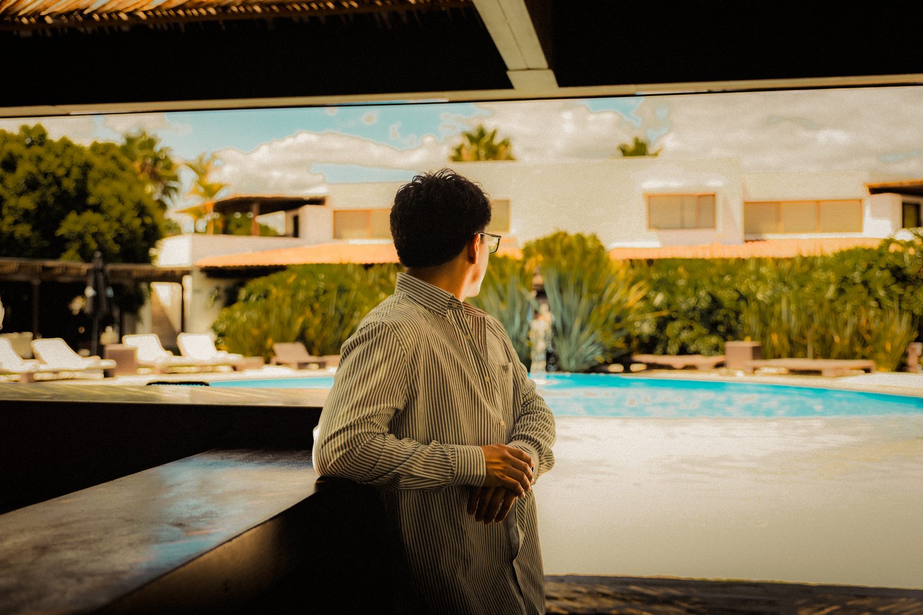 Edgar Lozada de espaldas, contemplando una alberca al atardecer
